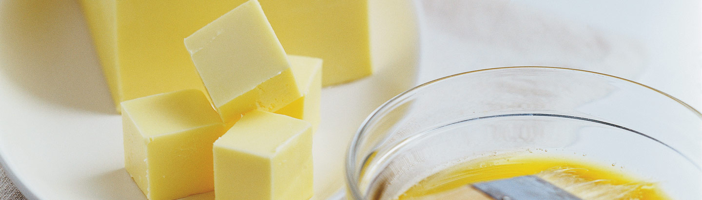 A photo of cubes of butter diced next to a bowl of melted butter